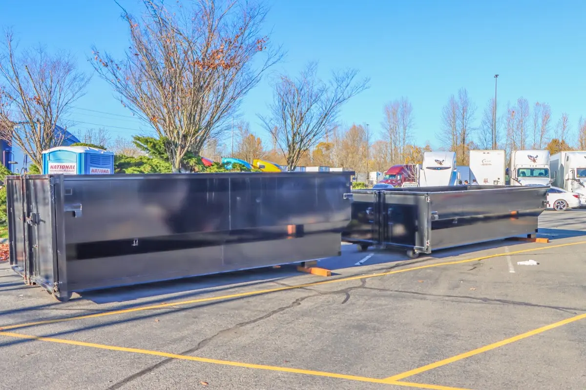 Professional dumpster rental service with roll-off container on residential driveway in Pepperell